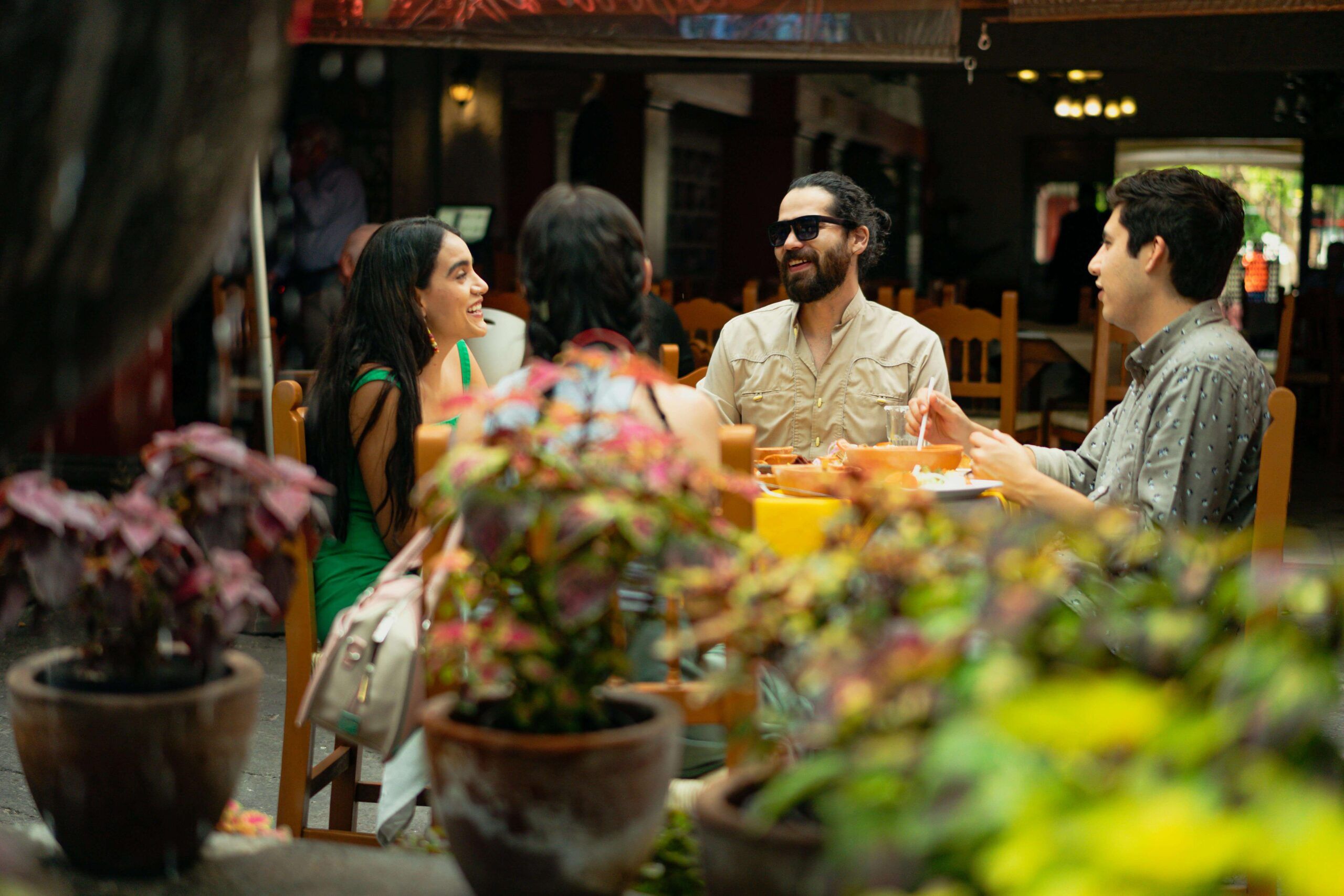 Four friends share a meal at an outdoor cafe, laughing and enjoying conversation. A nutritional therapist in Raleigh, NC, and disordered eating therapy in Raleigh, NC, can help you build a healthier relationship with food and regain control.