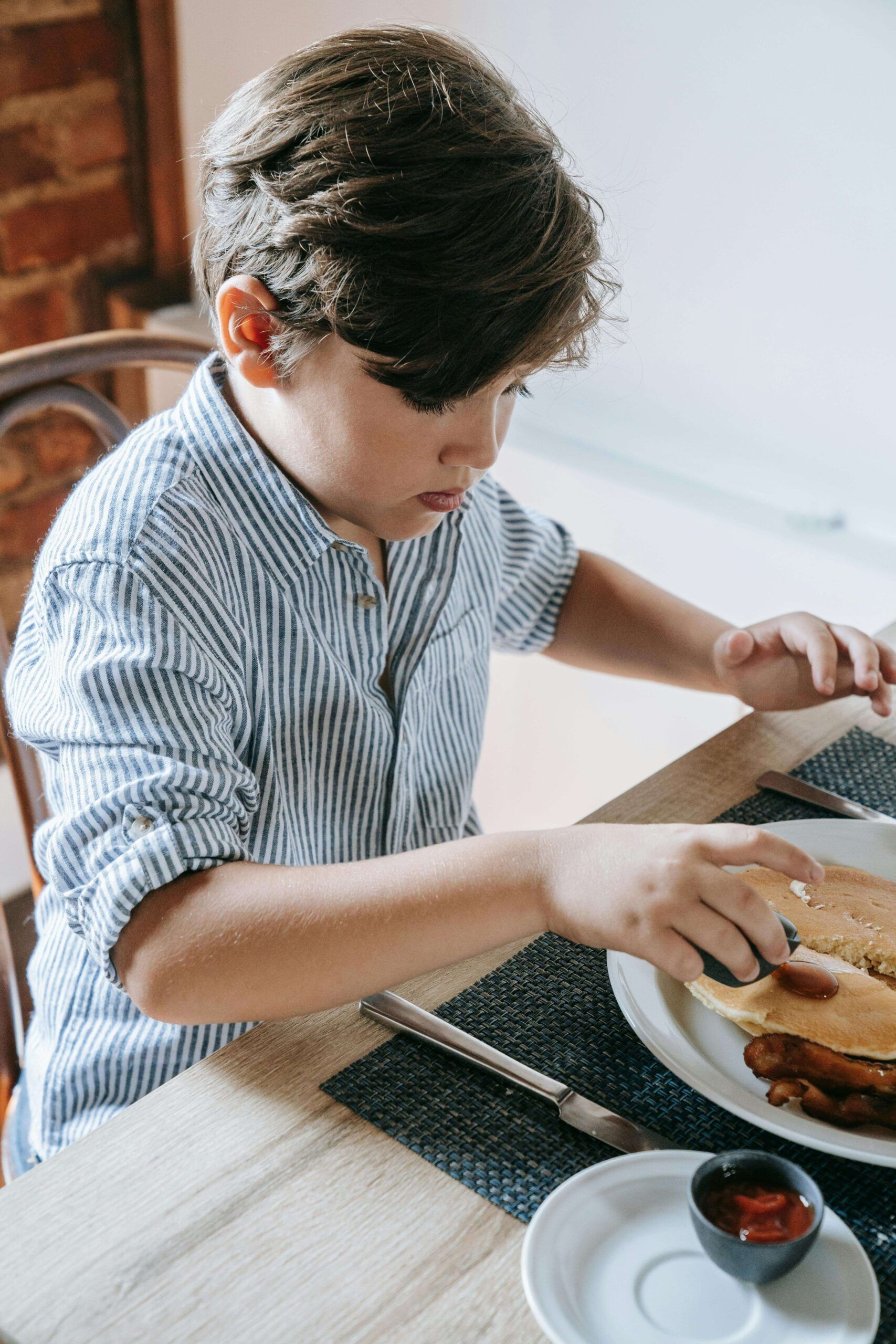 Child eating safe foods at table with support from nutrition counseling in Raleigh, NC and registered dietitian in Raleigh, NC for ARFID treatment without pressure