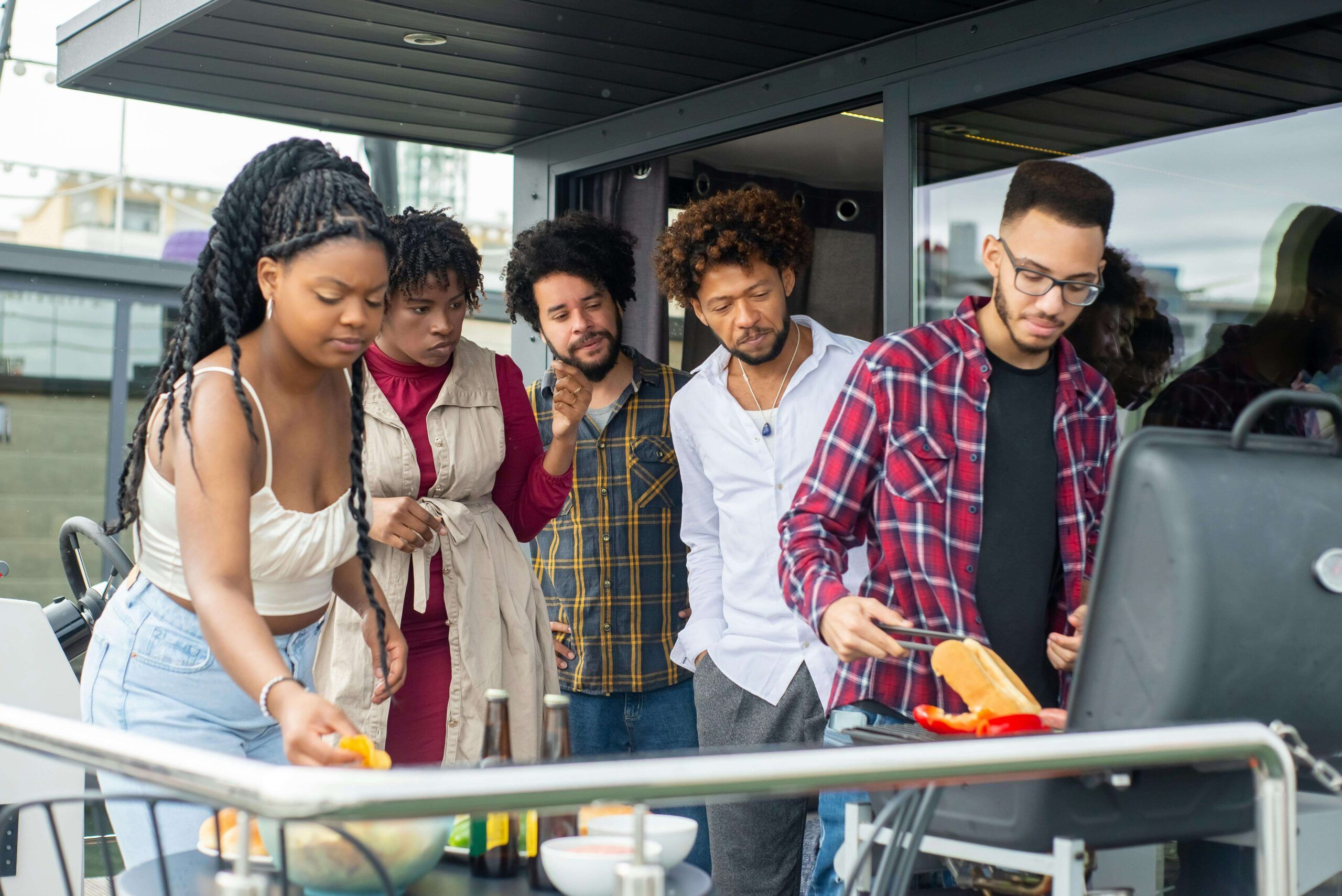 A group of people gathered around a grill at a summer gathering, connecting over food and conversation—representing how nutritional counseling in Raleigh, NC with a nutritional therapist can support you in navigating food and body comments with confidence and care.