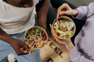 Two people enjoy balanced, colorful meals together—highlighting the approachable, personalized support offered through nutrition therapy in Raleigh, NC with a registered dietitian in Raleigh, NC.