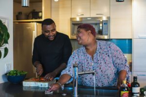 Two plus-size individuals enjoy preparing a meal together, reflecting the supportive, inclusive care offered through nutritious counseling for eating disorders in Asheville, NC and nutrition counseling in Raleigh, NC.