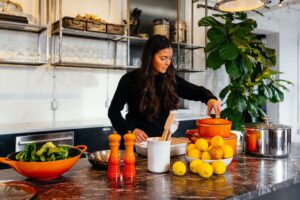A woman prepares a vibrant meal in a modern kitchen, symbolizing the supportive, personalized approach of nutritional counseling in Raleigh, NC and the guidance of nutrition counseling in Raleigh, NC for those navigating chronic health conditions.
