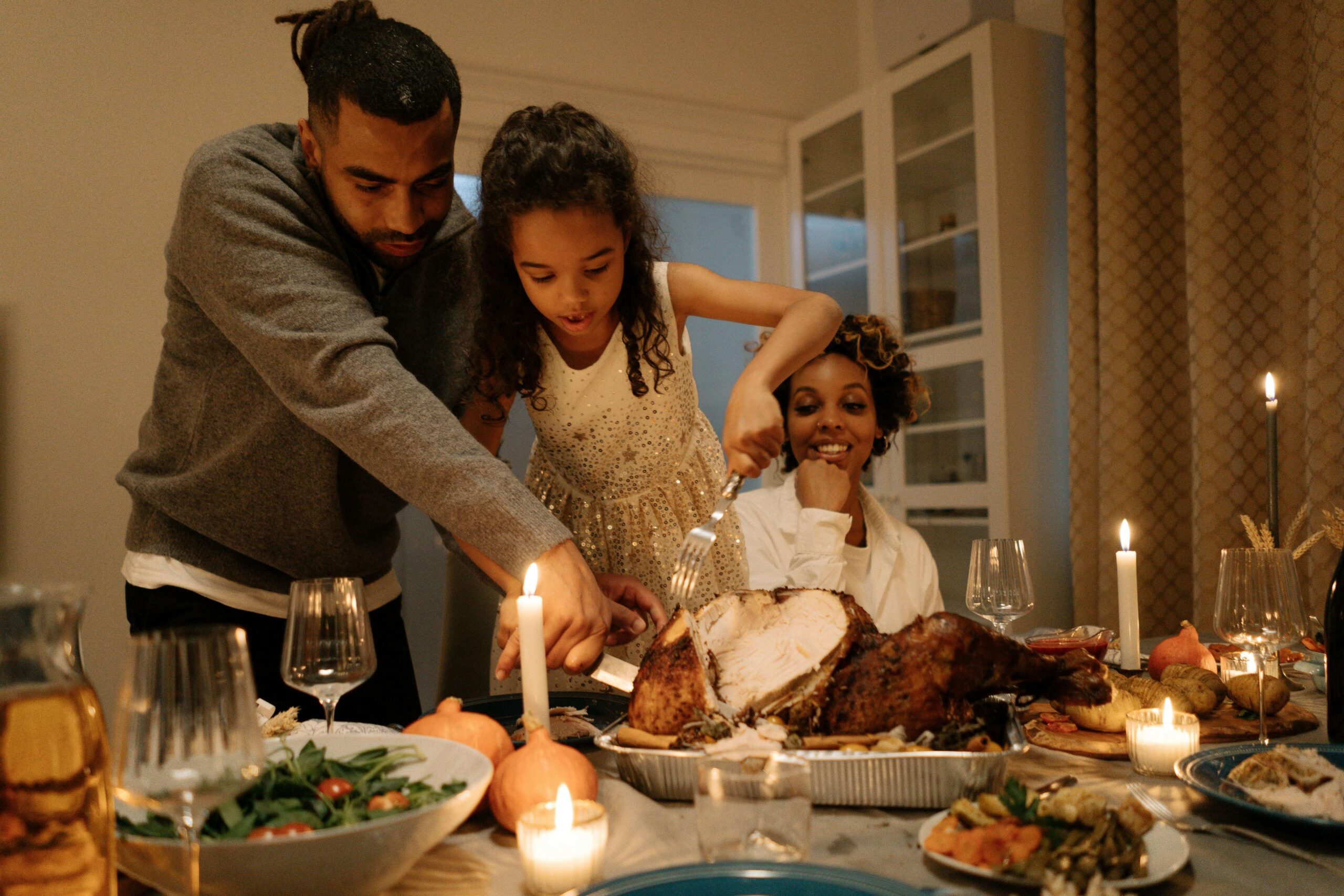 Parents and a child prepare and serve a festive dinner in a cozy home setting. When sensory processing disorder affects how kids experience food, how do parents reduce stress at the table? A registered dietitian in Raleigh, NC, can help families navigate holiday meals with flexibility and compassion.