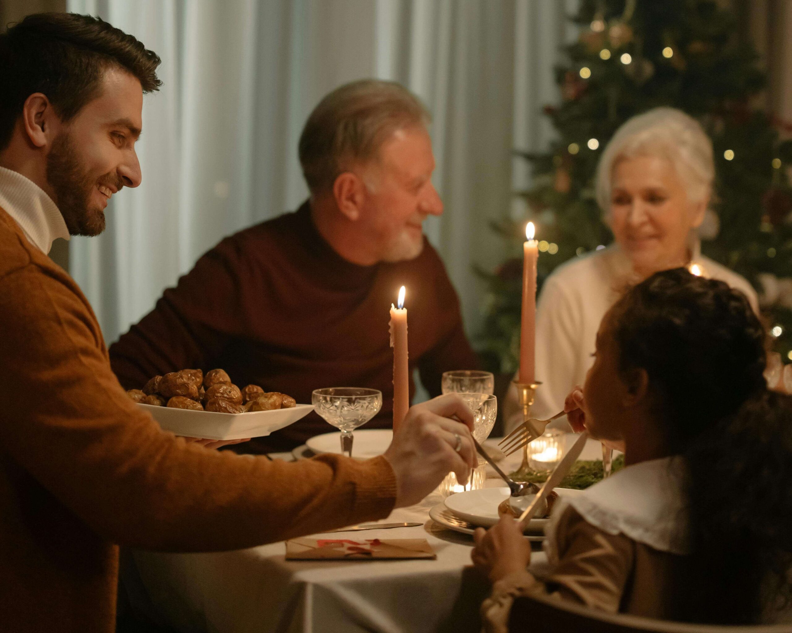 A family gathers around a candlelit table, sharing a warm holiday meal together. Holiday meals can be overwhelming for children sensitive to textures, smells, and sounds. Guidance from nutrition counseling in Raleigh, NC, helps families create calmer, more supportive food experiences during busy celebrations.