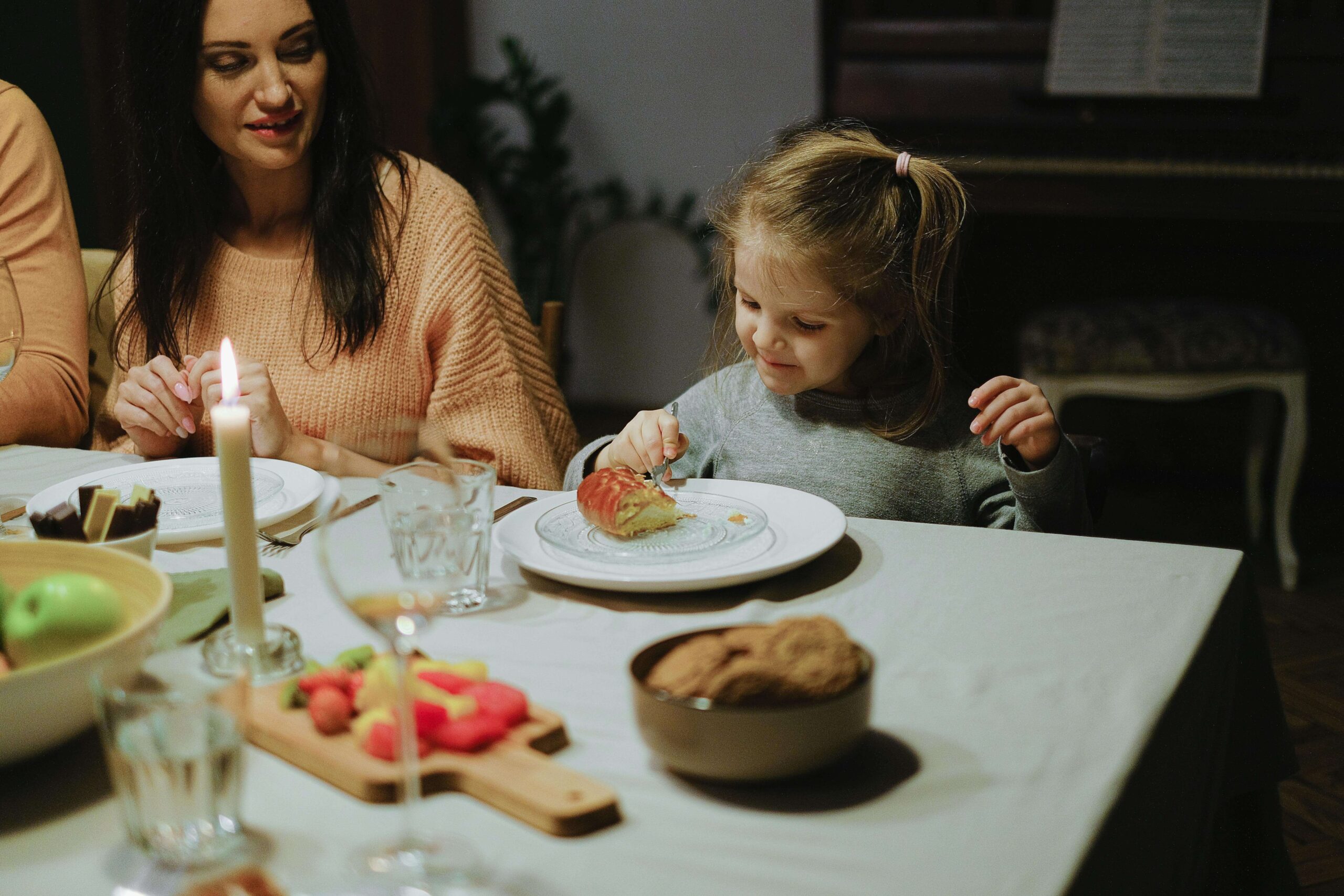 A young child sits at the dinner table, carefully exploring food while an adult offers gentle support nearby. How do holiday meals feel when sensory processing disorder makes flavors and textures intense? Working with nutrition counseling in Raleigh, NC, can help kids feel safer and more confident around food.