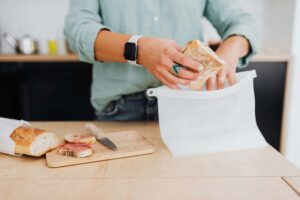 Person assembling a simple sandwich with bread and deli meat, showing how low-effort meals support neurodivergent nutrition without shame. Nutrition counseling in Raleigh, NC, from a registered dietitian in Raleigh, NC, honors these practical, sustainable choices.