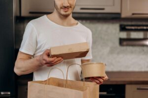 Man unpacking takeout containers in his kitchen, illustrating how neurodivergent adults often rely on convenient food solutions. Disordered eating therapy in Raleigh, NC, and nutrition therapy in Raleigh, NC, help reduce shame around these practical choices.