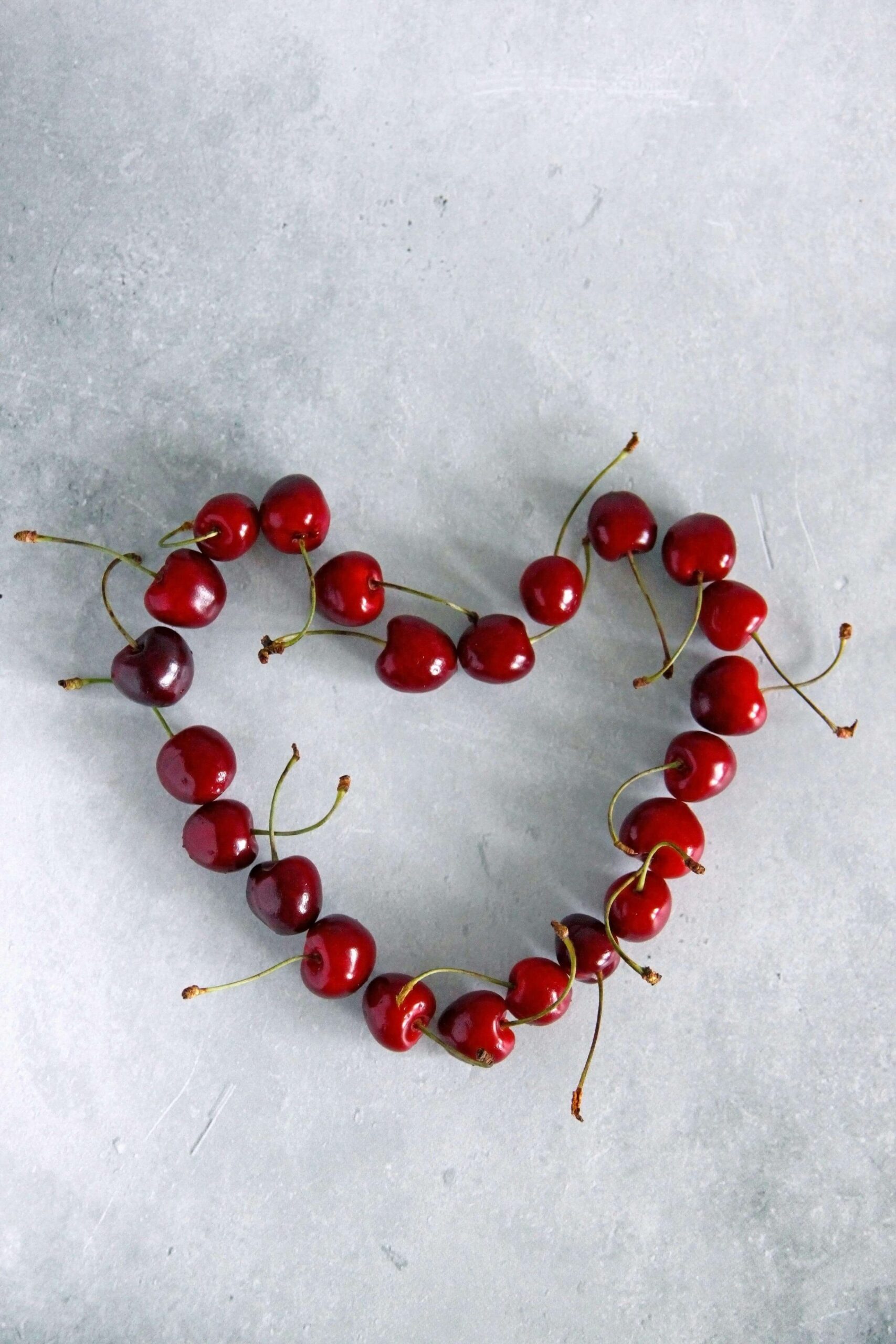 Fresh cherries arranged in a heart shape, symbolizing compassionate heart health care offered through nutrition counseling in Raleigh, NC with a registered HAES dietitian in Raleigh, NC who supports cardiovascular wellness without fear or shame.