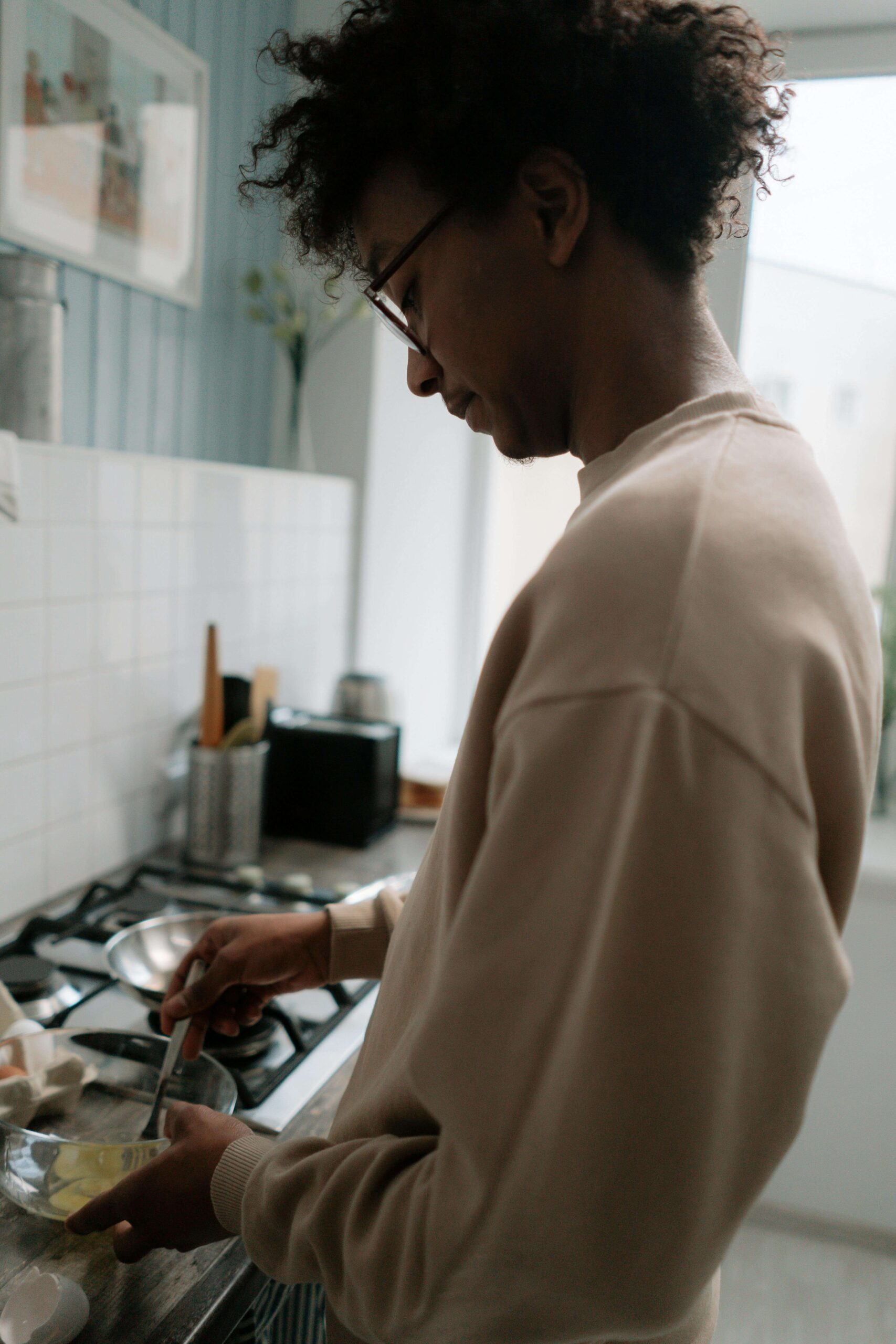 Person thoughtfully preparing food in their kitchen, representing the peaceful relationship with nourishment supported through nutrition therapy in Raleigh, NC with a registered dietitian in Raleigh, NC who offers HAES-informed care for OSFED and disordered eating.