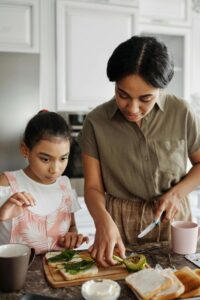 A mother and daughter prepare avocado toast together in a bright kitchen, reflecting the everyday relationship with nourishment supported through nutrition counseling for eating disorders in Raleigh, NC and with a dietitian in Hendersonville, NC.