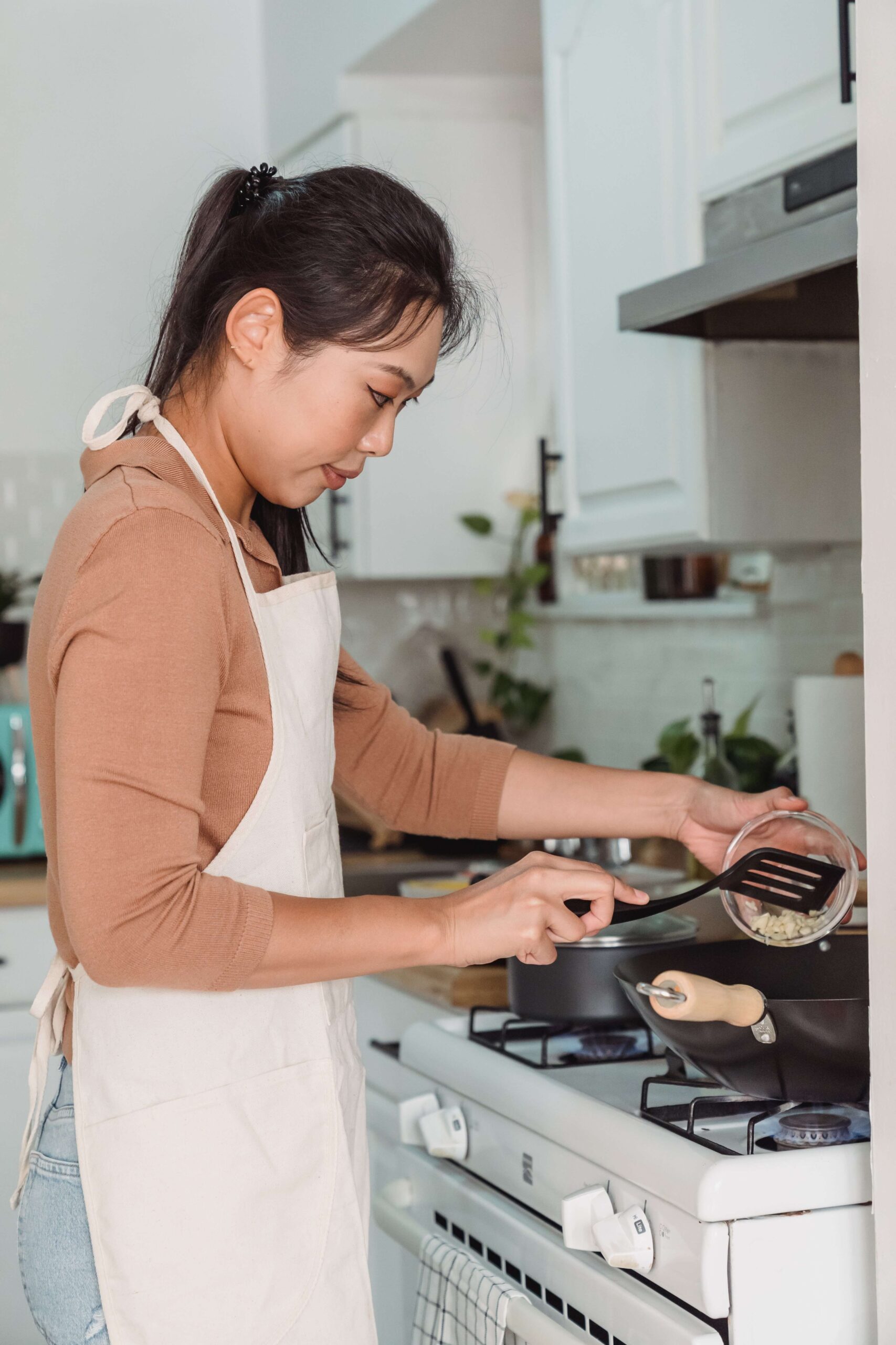 A nutritional therapist in Raleigh, NC holds a tomato while reviewing a food guide with a client at a kitchen counter, reflecting the warm, conversational approach of nutrition counseling in Raleigh, NC.